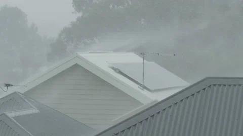 Heavy rain and winds hitting rooftops of houses in suburban area. Insurance, ext Video stock 131732025