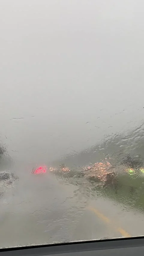 Heavy Rain on Car Windshield with Blurred Traffic Lights and Vehicles Stock Footage 337310889