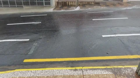 Heavy rain causes a strong flash flood on an asphalt street Stock Footage 331046836