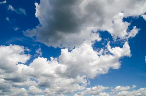 Heavy rain clouds flying in the deep blue summer sky Stock Photos
