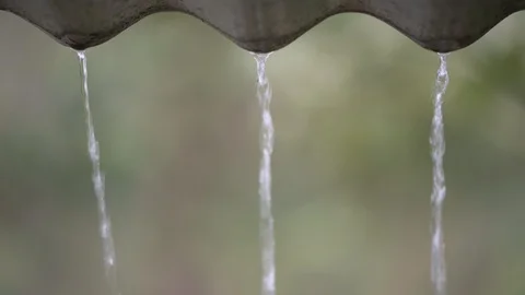 Heavy rain drops fall ,rain flows down from a roof rainy season strong winds and Stock Footage