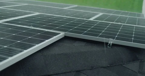 Heavy rain drops fall on solar panels on the roof of a private house Stock Footage 249474723