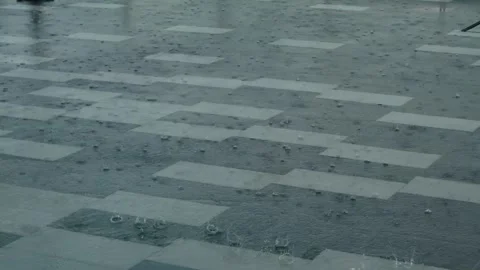 Heavy rain drops falling on city asphalt floor tiles during a heavy thunder.. Stock Footage 243340688