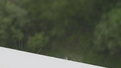Heavy rain drops falling down on the sill of window closeup Stock Footage 109428044