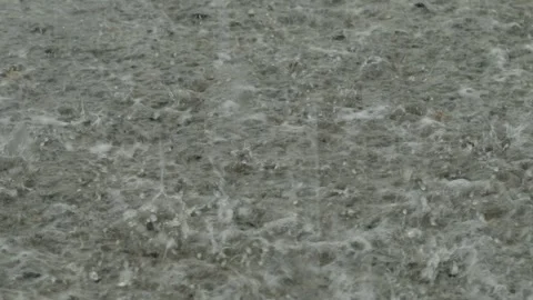 Heavy rain drops falling on a large puddle on concrete ground Stock Footage 338365422