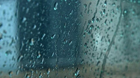 Heavy rain. Drops of rain flow down the dark glass of a car window. Vídeo Stock 113858333