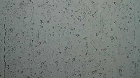 Heavy rain drops sliding down on window glass in rainy season Video stock 39705633