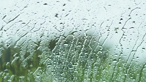 Heavy rain drops sliding down glass window with blurred green garden backgr.. Stock Footage 334119916