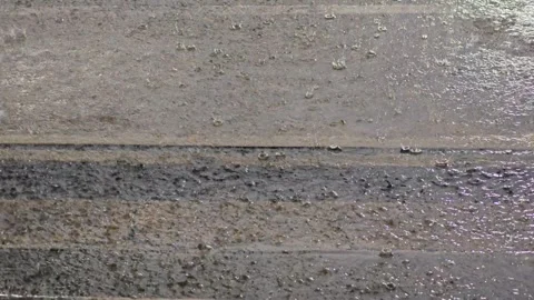 Heavy rain drops splashing on concrete road surface. Stock Footage 342308401