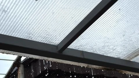 Heavy rain drumming on the transparent plexiglass roof. Beautiful rainy sce.. Fotos Stock