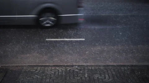 Heavy rain falling on asphalt road with cars driving by in the city. 動画素材 336982978