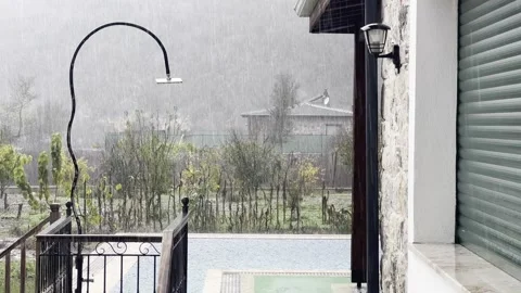 Heavy rain falling on a backyard swimming pool during a storm Vídeo Stock 323320665