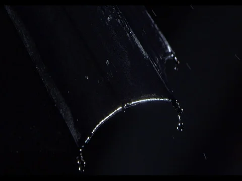 Heavy rain falling on a black umbrella, medium shot, slow motion Stock Footage 74221107