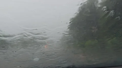 Heavy rain falling on car windshield during stormy weather Stock Footage 338409103
