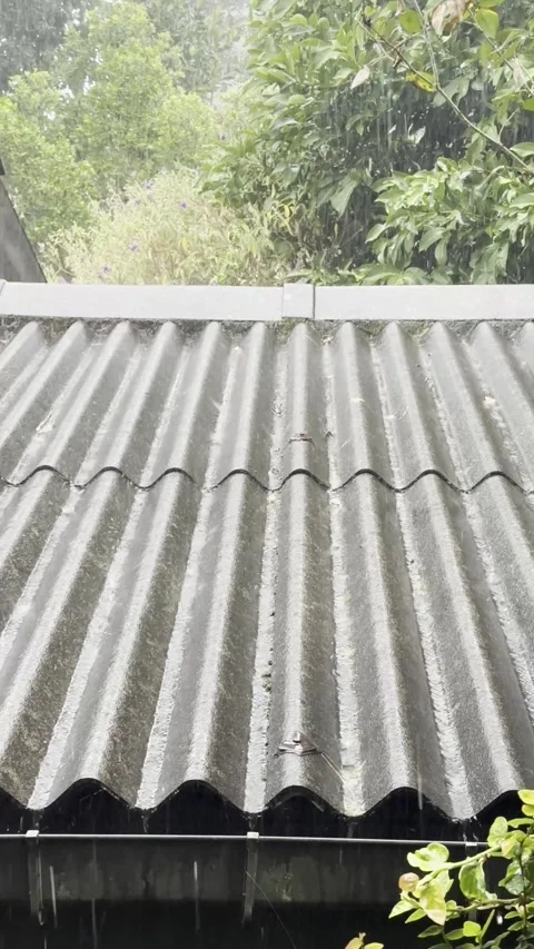 Heavy rain falling on corrugated grey roof Stock Footage 346637127