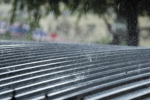Heavy Rain Falling on Corrugated Metal Roof Stockfoto's
