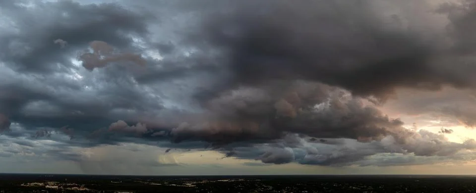 Heavy rain falling down from stormy clouds during thunderstorm on dark sky. M Stock Photos
