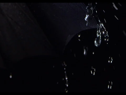Heavy rain falling on an edge of black umbrella, close-up, slow motion Stock Footage 74226927