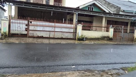 Heavy rain falling on an empty wet asphalt street in a residential neighborhood Stock Footage 335136339