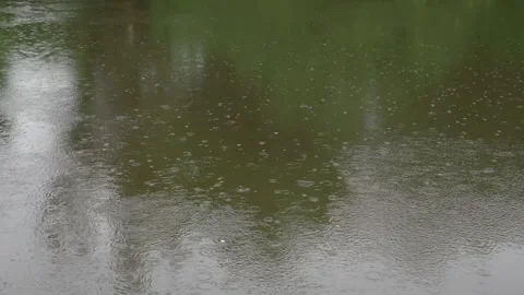 Heavy rain falling on a flowing river Vídeo Stock 245113936