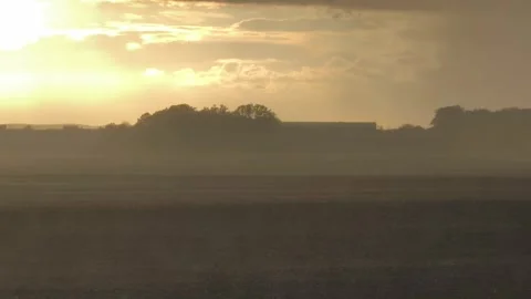 Heavy rain falling on misty field during golden sunset Stock Footage 346712357