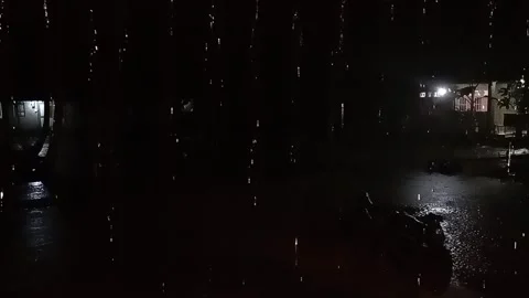 Heavy rain falling at night in a residential area. Video stock 320376459