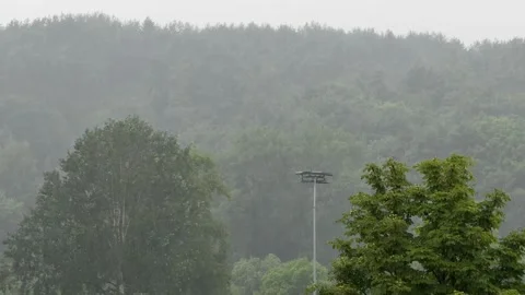Heavy Rain Falling Over Green Trees and Sports Grounds Stock Footage 340512535