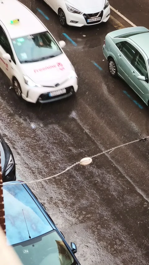 Heavy rain falling over parked cars on wet city street Stock Footage 346767393