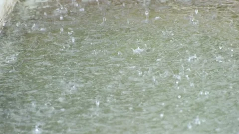 Heavy rain falling onto a puddle Stock Footage 342753731