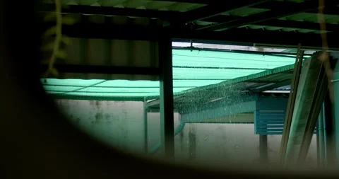 Heavy rain falling through green shade netting on a rooftop. Stock Footage 311596364
