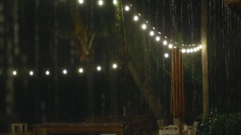 Heavy Rain Falling on Tropical Outdoor Patio with String Lights at Night. Stock Footage 338366563