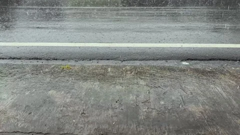 Heavy rain falling on a wet asphalt road with passing vehicle wheels Stock Footage 336713385