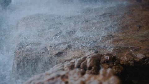 Heavy rain falling on wet brown rocks during a stormy weather event Stock Footage 341956328