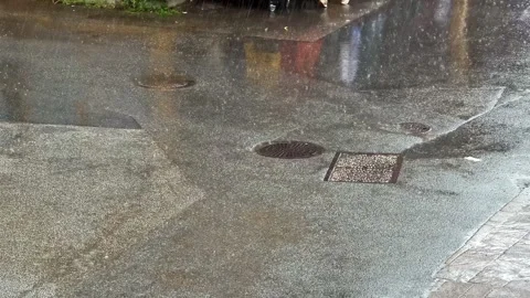 Heavy Rain Falling on Wet City Street With Manhole Covers Stock Footage 341537332