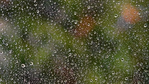 Heavy rain falling on window.green bokeh in background from trees.spring rain Stock Footage 132734661