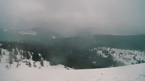 Heavy rain falls among the mountains on the trees, snowy mountains, light fog Stock Footage 238643339