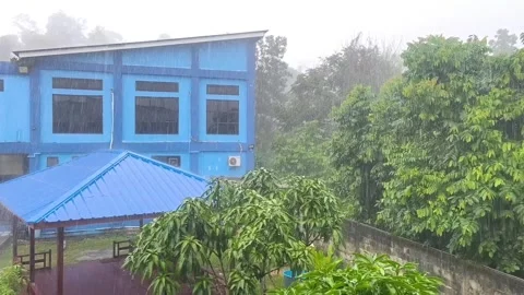 Heavy rain falls down heavily on a blue building architecture Stock Footage 337526934