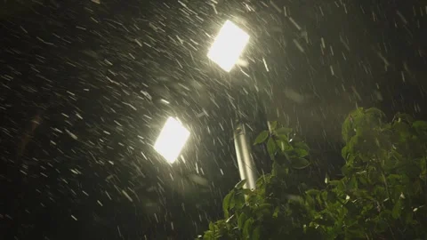 Heavy Rain Falls at Night Illuminated by Bright Street Lights Stock Footage 337409041