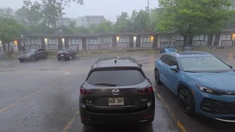 Heavy rain falls over an apartment parking lot with parked cars 스톡 동영상 348126053