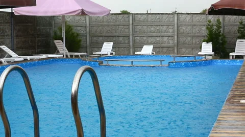 Heavy rain falls into a swimming pool 스톡 동영상 64971874