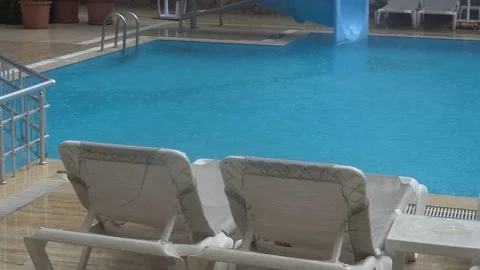 Heavy rain falls into a swimming pool. Not season, dirty abandoned pool Stock Footage 81990399