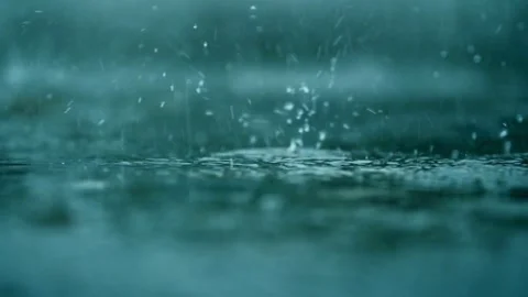Heavy rain falls on a wet surface creating splashes Video stock 332284217