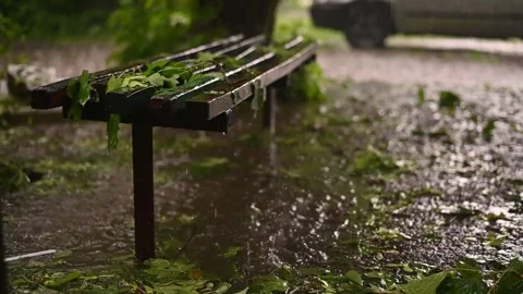 Heavy rain flooding park bench. close-up of bench partially submerged in Vídeo Stock 331851424
