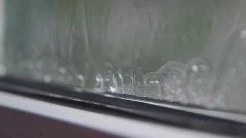 Heavy rain flows down the window. Rain in slow motion. Raindrops falling in slow Stock Footage 264540924