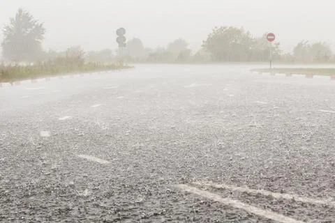 Heavy rain with hail is falling along the highway. Stock Photos