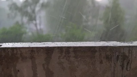 Heavy rain hail pours down outside as water droplets splash on the ledge of a Stock Footage 339024151