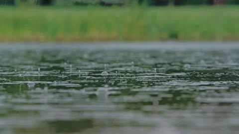 Heavy Rain Hits A Large Puddle Creating Ripples And Splashes Across Wet Surface Stock Footage 346057959