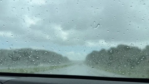 Heavy rain hits a windshield with windshield wipers moving Stock Footage 329575044