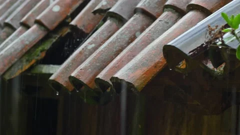 Heavy Rain Hitting Old House Roof With Missing Tiles during Thunderstorm Stock Footage 196897694