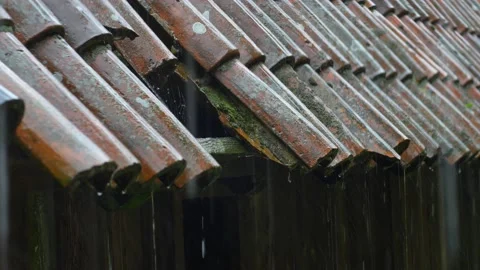 Heavy Rain Hitting Old House Roof With Missing Tiles during Thunderstorm Stock Footage 196897723